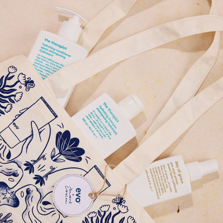 Evo hair care products on a beige fabric background