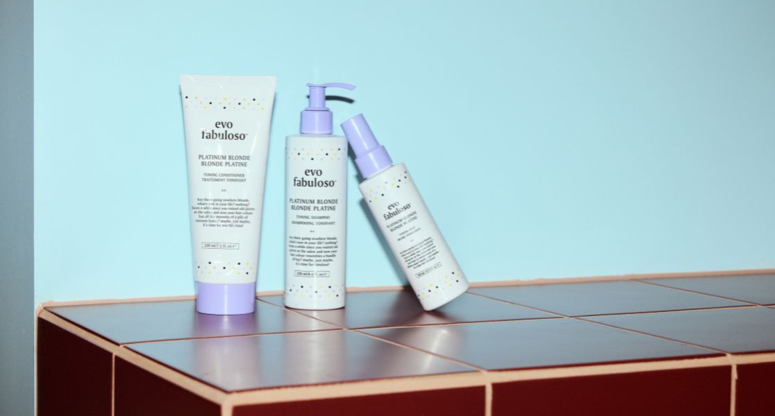 Three skincare products on a tiled surface with a light blue background