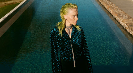 Person with green hair standing by a pool