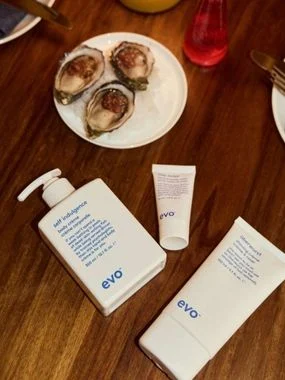 Evo skincare products on a wooden table with oysters in the background